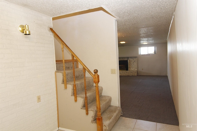 930 Coulter Ln, Clarkston, WA 99403 - stairs featuring a textured ceiling, a brick fireplace, tile patterned floors, carpet, and brick wall