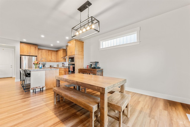 dining area featuring sink and light wood-type flooring