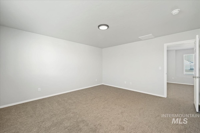 709 W Smoky Quartz St, Kuna, ID 83634 - empty room featuring a smoke detector, dark carpet, and baseboards