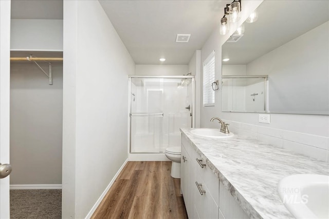 709 W Smoky Quartz St, Kuna, ID 83634 - bathroom featuring a stall shower, toilet, double vanity, and wood finished floors