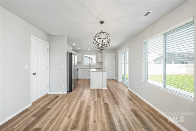 709 W Smoky Quartz St, Kuna, ID 83634 - kitchen featuring a chandelier, freestanding refrigerator, white cabinets, light wood-style floors, and recessed lighting