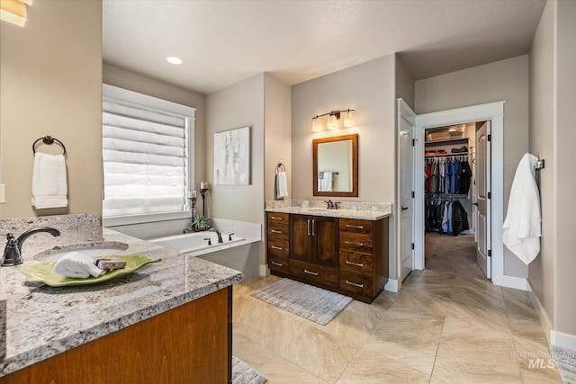 11714 W Pinewood River Ln, Star, ID 83669 - bathroom with two vanities, a bath, a spacious closet, and recessed lighting