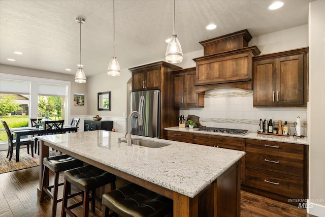 11714 W Pinewood River Ln, Star, ID 83669 - kitchen featuring appliances with stainless steel finishes, a kitchen island with sink, light stone counters, recessed lighting, and backsplash