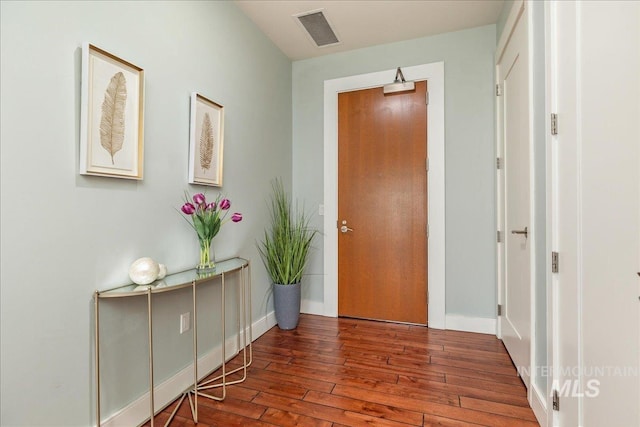 foyer entrance with visible vents, wood-type flooring, and baseboards