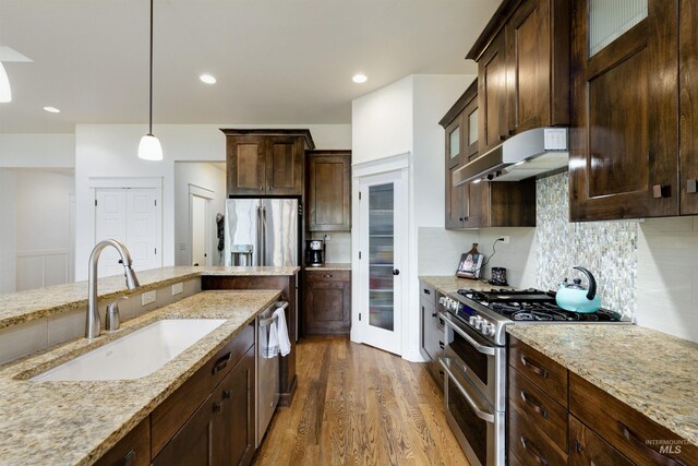 6859 N Topaz Jewel Pl, Meridian, ID 83646 - kitchen featuring stainless steel appliances, a sink, range hood, light stone countertops, and recessed lighting