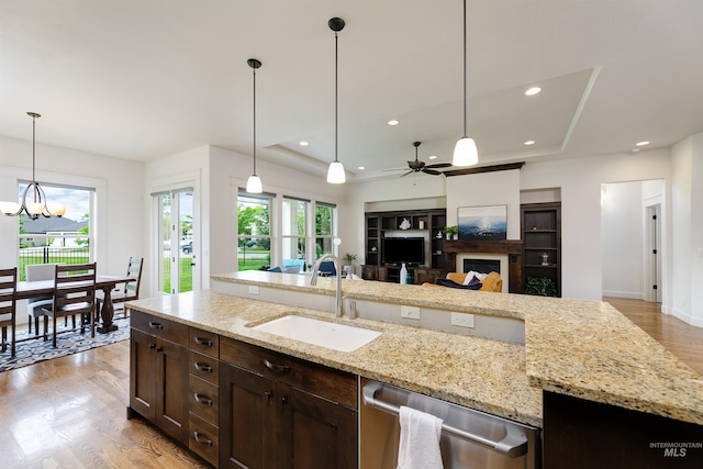 6859 N Topaz Jewel Pl, Meridian, ID 83646 - kitchen featuring a sink, a fireplace, dishwasher, dark brown cabinets, and light wood finished floors