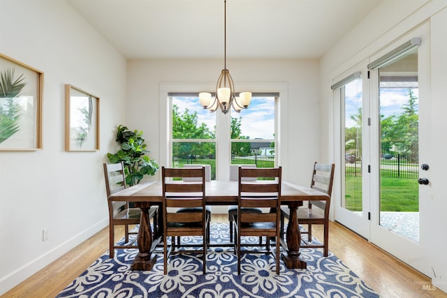 6859 N Topaz Jewel Pl, Meridian, ID 83646 - dining area with plenty of natural light, a chandelier, light wood-style flooring, and baseboards
