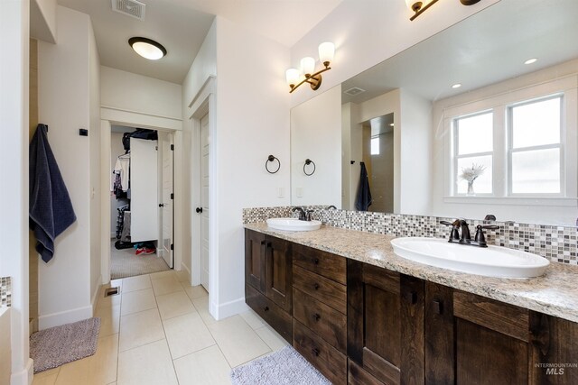 6859 N Topaz Jewel Pl, Meridian, ID 83646 - full bath featuring tile patterned floors, double vanity, baseboards, a spacious closet, and decorative backsplash