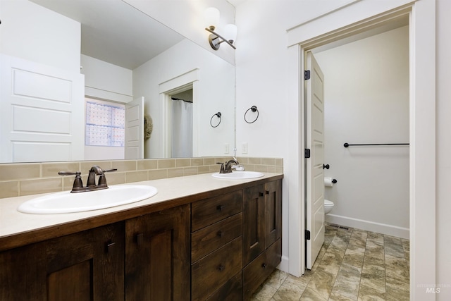 6859 N Topaz Jewel Pl, Meridian, ID 83646 - full bath with decorative backsplash, toilet, double vanity, and baseboards
