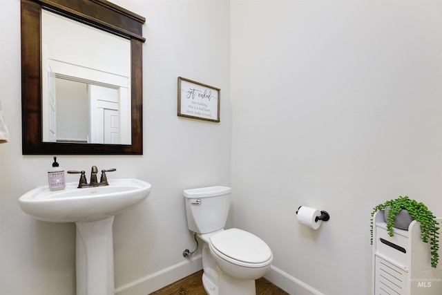 6859 N Topaz Jewel Pl, Meridian, ID 83646 - bathroom featuring baseboards, toilet, a sink, and wood finished floors
