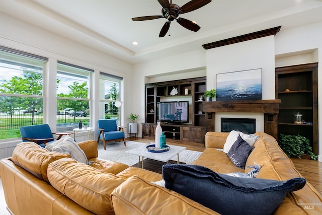 6859 N Topaz Jewel Pl, Meridian, ID 83646 - living room featuring wood finished floors, a ceiling fan, and a glass covered fireplace