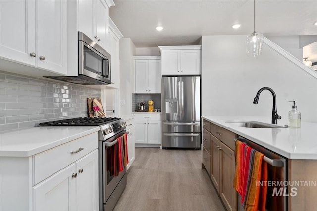 1867 W Wind Drift St, Meridian, ID 83646 - kitchen featuring appliances with stainless steel finishes, a sink, light wood-type flooring, white cabinetry, and recessed lighting