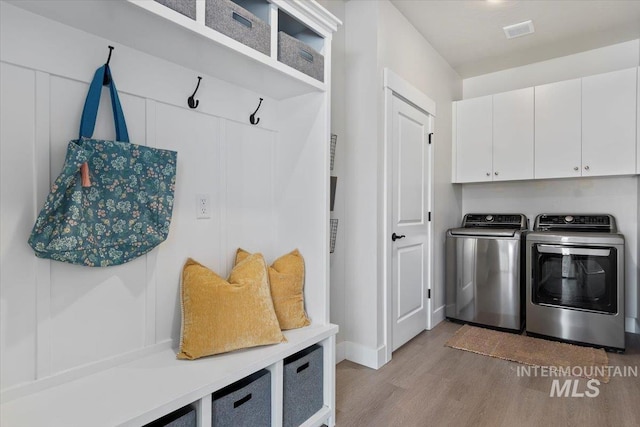 1867 W Wind Drift St, Meridian, ID 83646 - clothes washing area with separate washer and dryer, light wood-style floors, cabinet space, and baseboards