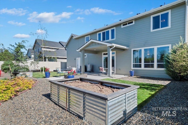 1867 W Wind Drift St, Meridian, ID 83646 - rear view of house featuring a patio, fence, and a garden