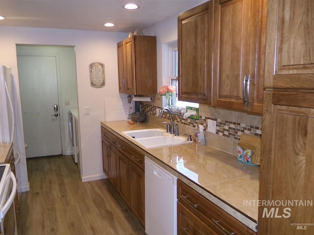 1835 Lincoln St, Mountain Home, ID 83647 - kitchen with decorative backsplash, white dishwasher, wood finished floors, a sink, and recessed lighting