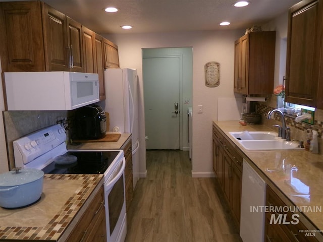 1835 Lincoln St, Mountain Home, ID 83647 - kitchen featuring a sink, light wood finished floors, white appliances, brown cabinetry, and recessed lighting