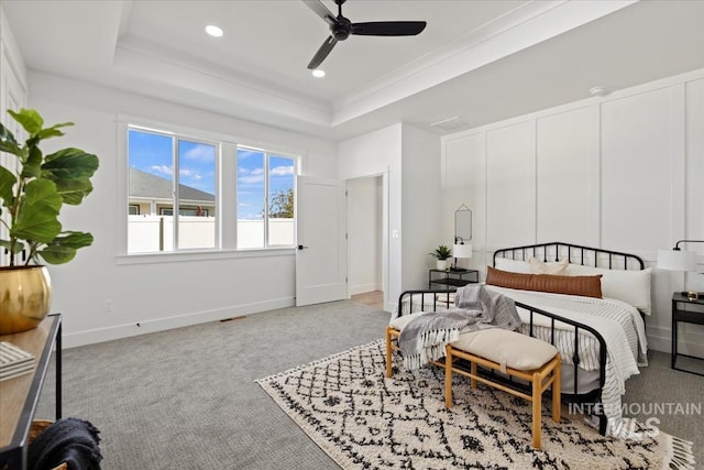 bedroom with crown molding, light colored carpet, a raised ceiling, and ceiling fan