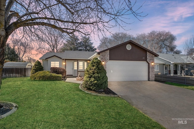 ranch-style house with brick siding, a yard, concrete driveway, an attached garage, and fence