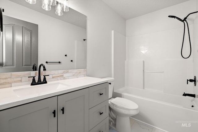 bathroom featuring marble finish floor, bathing tub / shower combination, toilet, vanity, and a textured ceiling