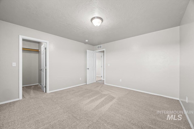 120 Pilgrim Way, Middleton, ID 83644 - unfurnished bedroom featuring a textured ceiling, carpet flooring, baseboards, a walk in closet, and a closet