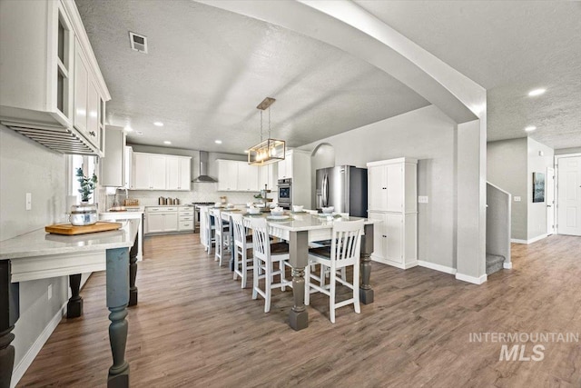 120 Pilgrim Way, Middleton, ID 83644 - dining room with baseboards, dark wood-style floors, a textured ceiling, recessed lighting, and arched walkways