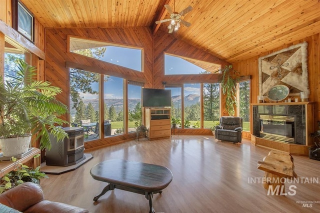 sunroom / solarium with wood ceiling, lofted ceiling with beams, ceiling fan, and a wealth of natural light