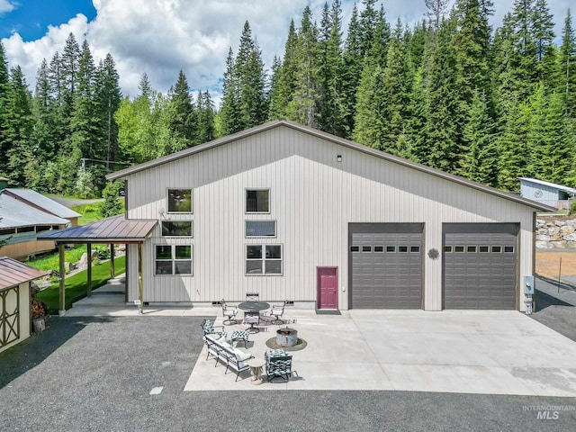 110 S 3rd Ave, Pierce, ID 83546 - view of front of home with a detached garage, a standing seam roof, metal roof, and a view of trees