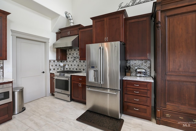 110 S 3rd Ave, Pierce, ID 83546 - kitchen featuring appliances with stainless steel finishes, under cabinet range hood, decorative backsplash, light stone countertops, and light tile patterned floors