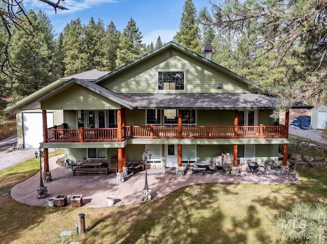 back of property featuring a deck, a yard, and a patio area