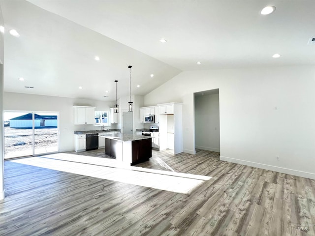 kitchen with stainless steel appliances, open floor plan, white cabinets, and light wood-style flooring