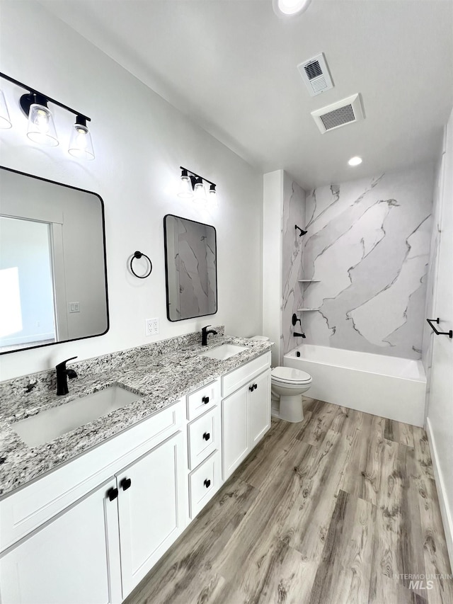 full bath featuring visible vents, a sink, and wood finished floors