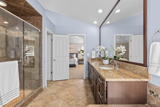 ensuite bathroom featuring a shower stall, ensuite bath, lofted ceiling, and a sink