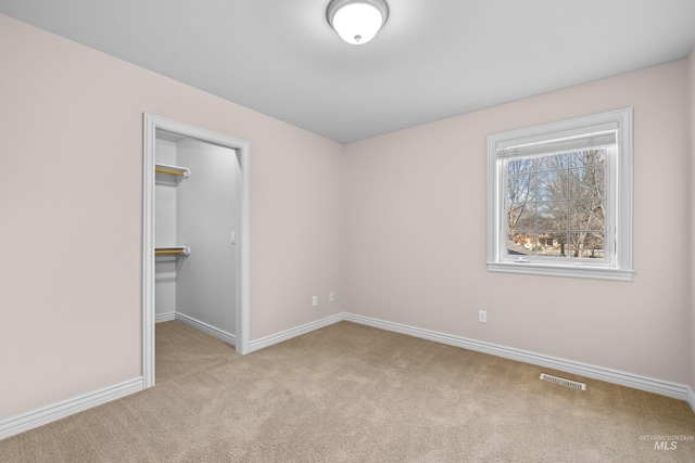 spare room with visible vents, carpet floors, and baseboards