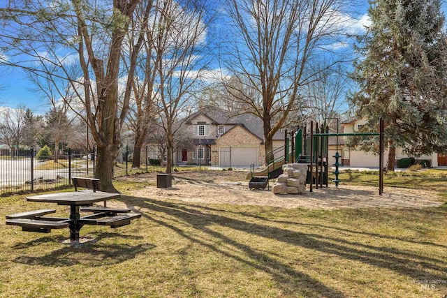 view of home's community featuring playground community, a yard, and fence