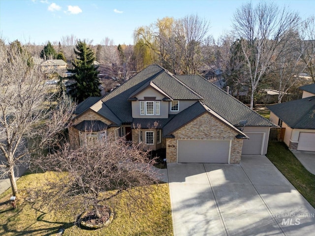 view of front of property featuring an attached garage, brick siding, and driveway