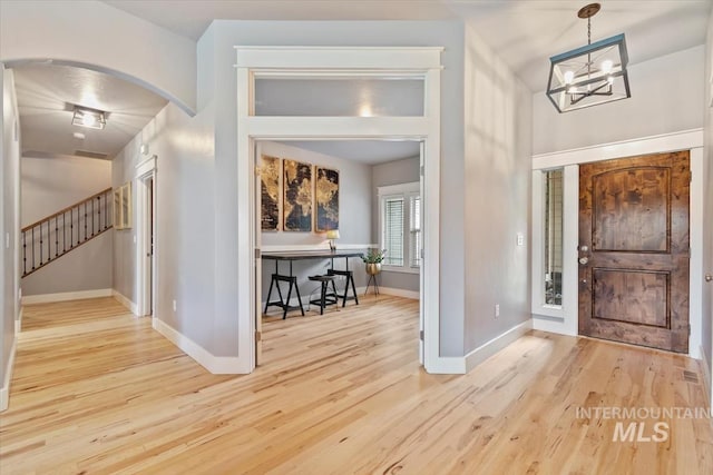 12231 W Caribee Inlet Dr, Star, ID 83669 - entryway featuring arched walkways, wood finished floors, stairway, and a chandelier