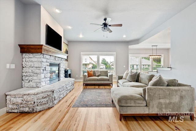 12231 W Caribee Inlet Dr, Star, ID 83669 - living area with a ceiling fan, healthy amount of natural light, wood finished floors, a stone fireplace, and recessed lighting