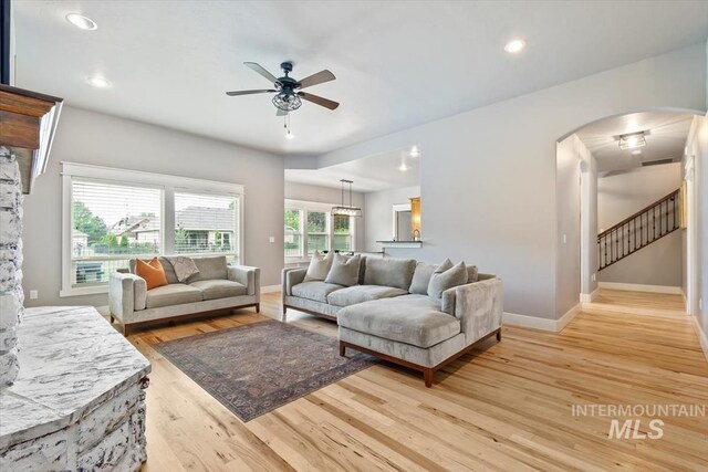12231 W Caribee Inlet Dr, Star, ID 83669 - living room featuring arched walkways, ceiling fan, light wood-type flooring, recessed lighting, and stairway