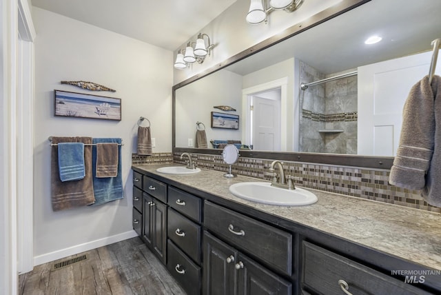 full bathroom featuring tasteful backsplash, visible vents, wood finished floors, and a sink