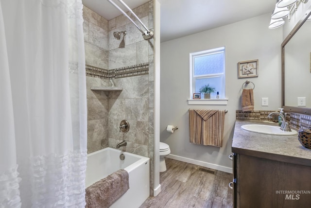 bathroom featuring shower / bath combo with shower curtain, toilet, wood finished floors, baseboards, and vanity