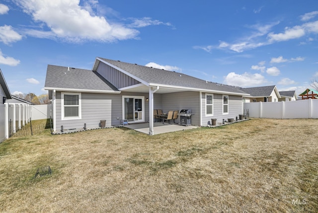 back of property with a yard, a shingled roof, a fenced backyard, and a patio area