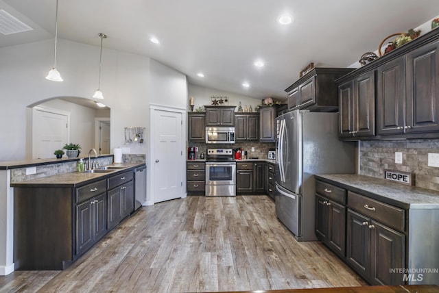 kitchen featuring a sink, stainless steel appliances, light wood-style floors, lofted ceiling, and dark brown cabinets