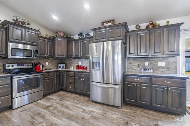 kitchen featuring light wood-type flooring, tasteful backsplash, dark brown cabinetry, appliances with stainless steel finishes, and light countertops