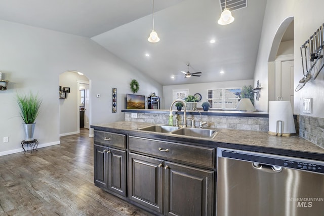 kitchen with visible vents, a sink, stainless steel dishwasher, arched walkways, and dark brown cabinetry