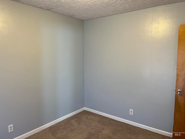 carpeted spare room featuring a textured ceiling