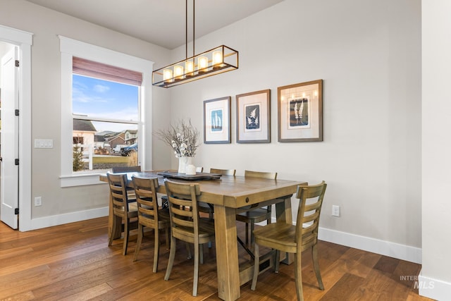 dining area with an inviting chandelier, baseboards, and wood finished floors