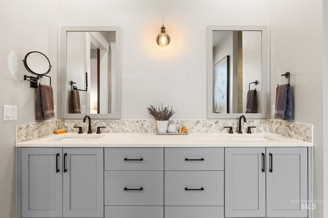 bathroom featuring a sink, decorative backsplash, and double vanity