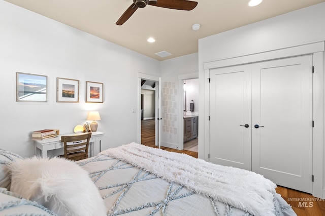 bedroom featuring wood finished floors, visible vents, ensuite bath, recessed lighting, and a closet