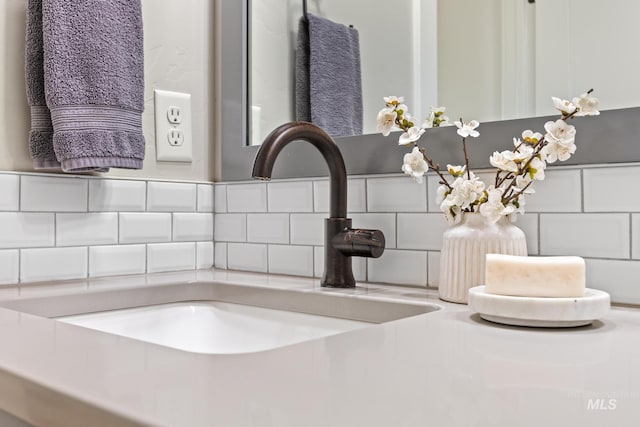 interior details featuring a sink and backsplash