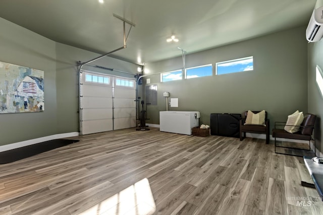 garage with baseboards, an AC wall unit, and refrigerator